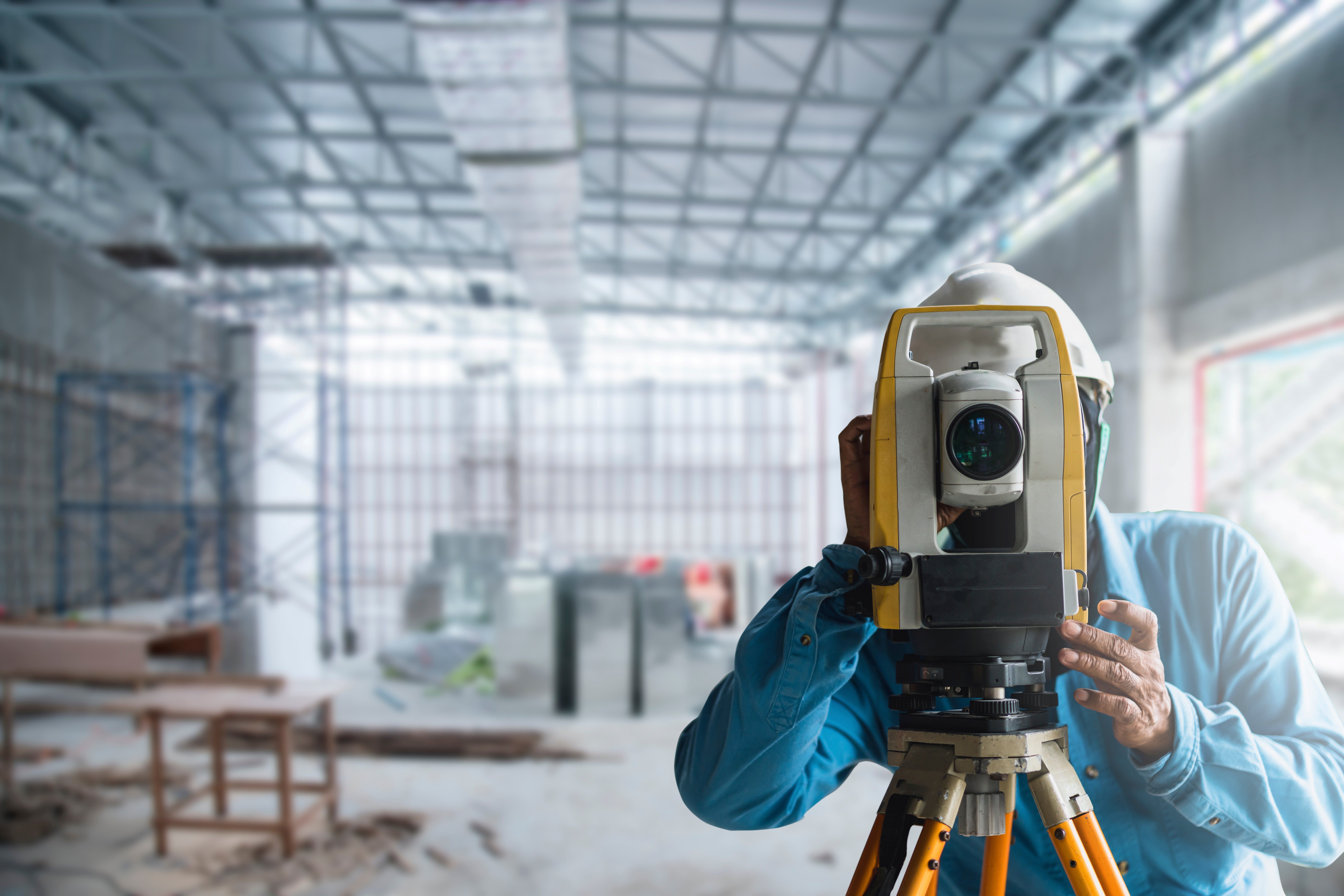 Surveyor With Level Camera At New Construction Site